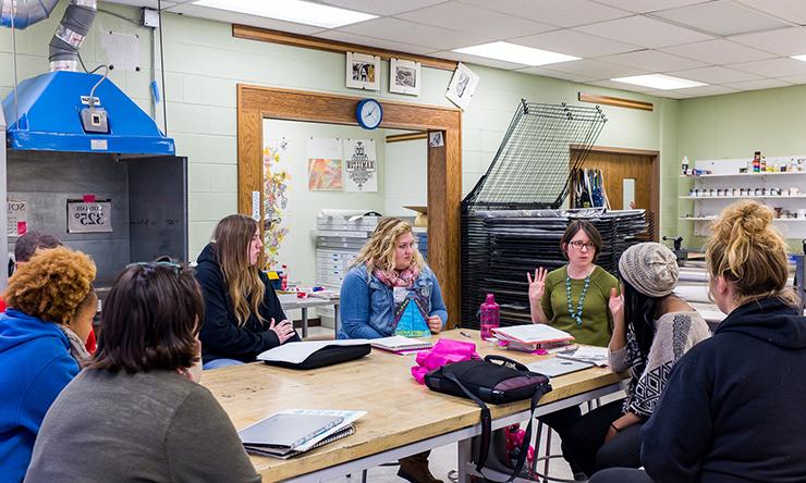 art professor and students around table